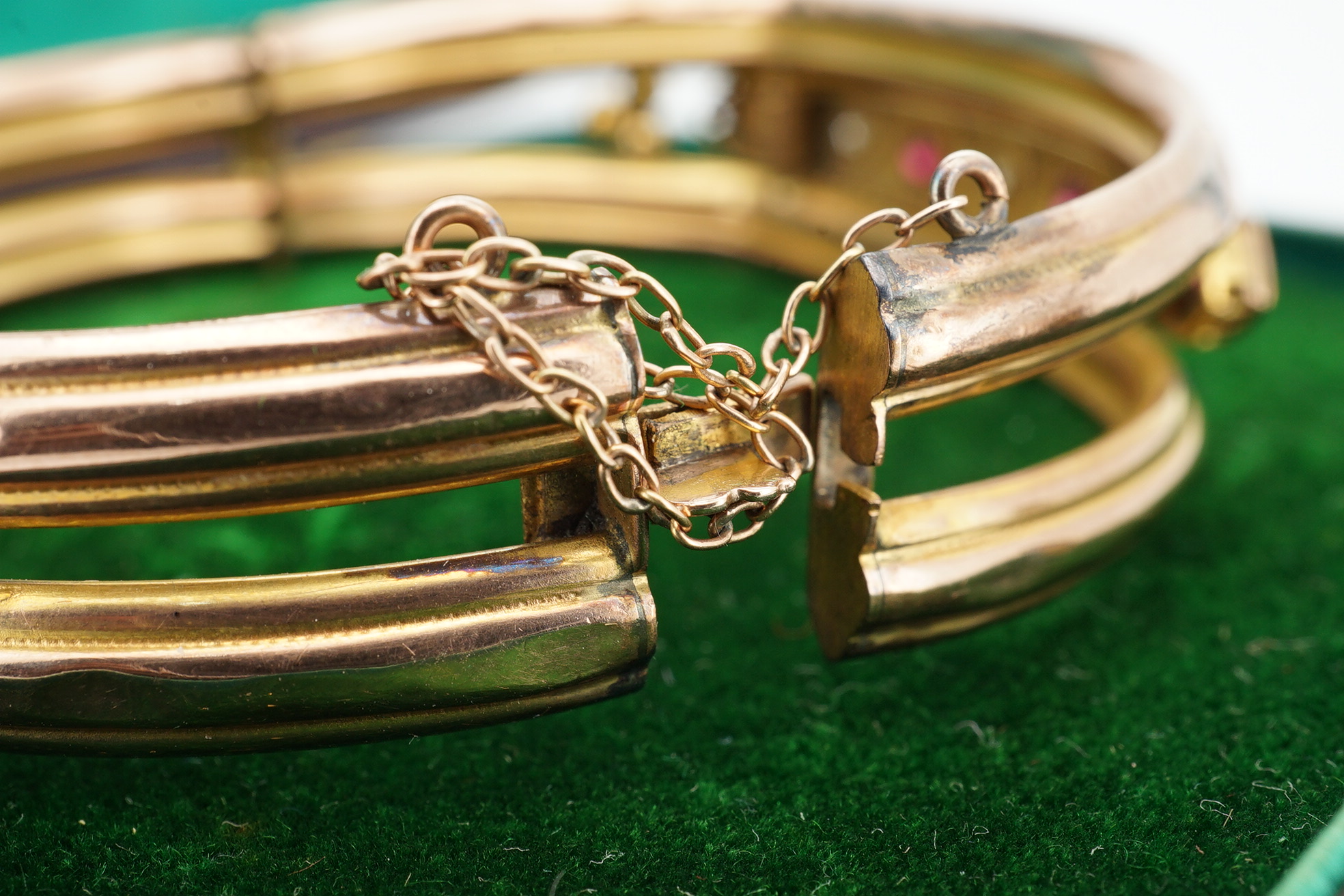 An Edwardian 9ct gold, and gypsy set ruby and diamond set hinged bangle, gross 11.4 grams, together with a gilt metal hinged bangle. Condition - poor.